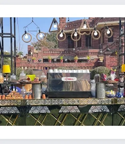 The full view of our extensive tea and coffee station at an outdoor event, featuring a professional coffee machine and rustic decor.
