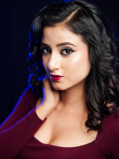 A classic Hollywood glam look with soft curls, a sharp winged liner, and a bold red lip.