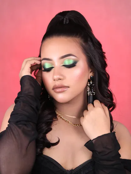 A close-up of the green glitter eye makeup, showing the beautiful sparkle and blend of colors on the eyelid.