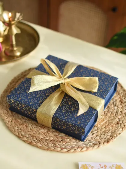 The premium blue and gold gift box for my Healthy Bites Hamper, tied with a golden ribbon.