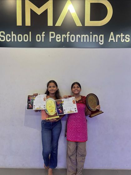 Our winners posing with their awards under the IMAD sign. We provide a platform for talented students to compete and achieve their goals.