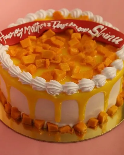 Another angle of our beautiful Mother's Day mango cake, showing the glossy drip and fresh fruit.