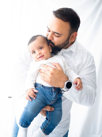 A proud father's kiss for his happy baby.