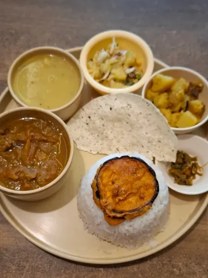 This is our Axomia style Chicken Thali. It comes with fragrant Joha rice, our classic dal, aloo pitika (mashed potato), begun bhaja (fried brinjal), and a spicy jola bota chutney. It’s a taste of a traditional Assamese home.