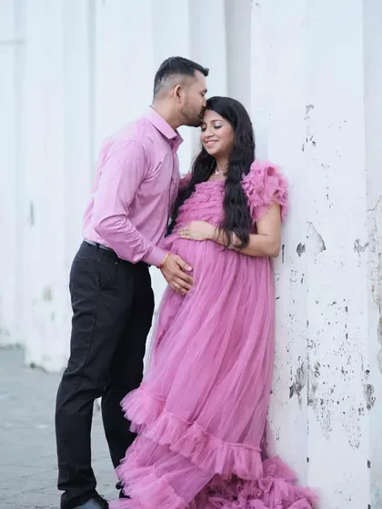 A tender moment between parents-to-be. This soft pink ruffled maternity gown is perfect for capturing the sweet anticipation of your little one's arrival.
