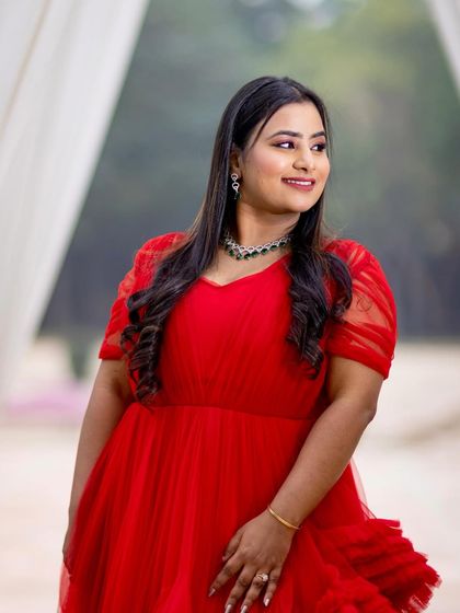 A beautiful red gown look for a pre-wedding shoot. The makeup is glamorous with a subtle shimmer on the eyes and a soft red lip.