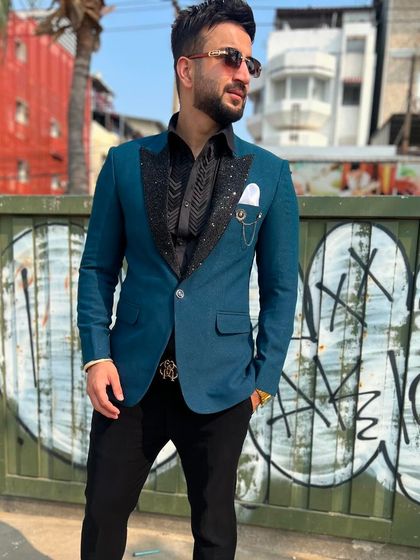 A close-up of the teal blazer, showing the detailed texture on the lapel and the sleek pocket square. It's all about the small details that complete the look.