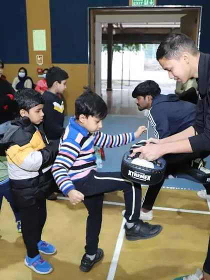 An instructor working with a group of kids on their kicking technique. We provide personalized attention to ensure they are learning correctly.