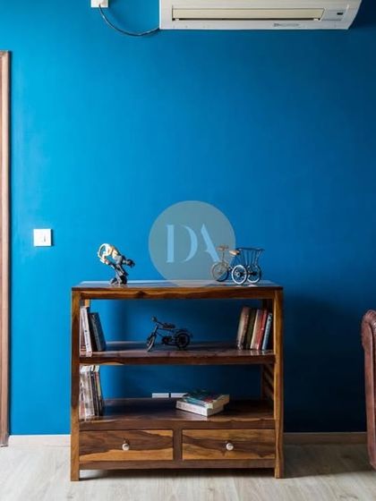 Another view of the bold blue lounge area, featuring a classic Chesterfield sofa. This space demonstrates our love for using dark, captivating colors to create depth and character in a room.