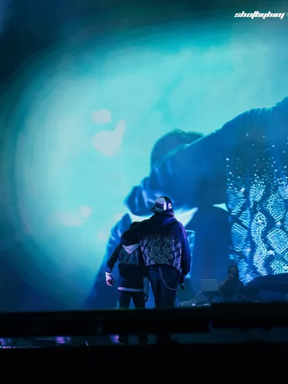 A view from behind Rich the Kid as he looks out at the massive screen and stage at Rolling Loud India. This gives a unique, artist-perspective shot.