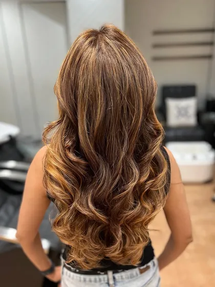 An exquisite hair transformation with an expert balayage service. The result is a seamlessly blended, sun-kissed look.