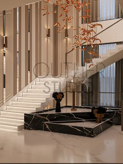 A wide view of the grand staircase, featuring a sculptural black marble platform at its base. The design combines rhythm and elegance with its layered lighting, wall panelings, and statement art.