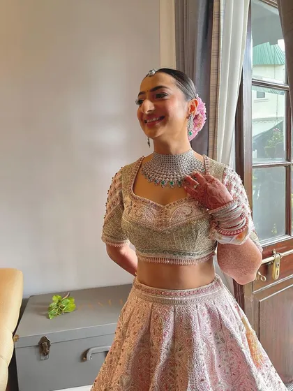 A candid shot of the bride. The floral bun adds a touch of softness and romance to her overall look, perfect for her pastel outfit.