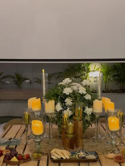 The romantic tablescape for the proposal dinner. We included a beautiful floral centerpiece, dozens of candles, a cheese board, and a projector screen for a personal slideshow.
