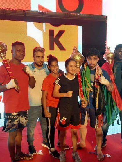 The team holding their trophies after a successful night of fights at the pro MMA event in Indore.