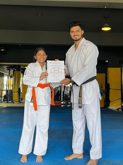 This student proudly holds her certificate after being promoted to the next rank.