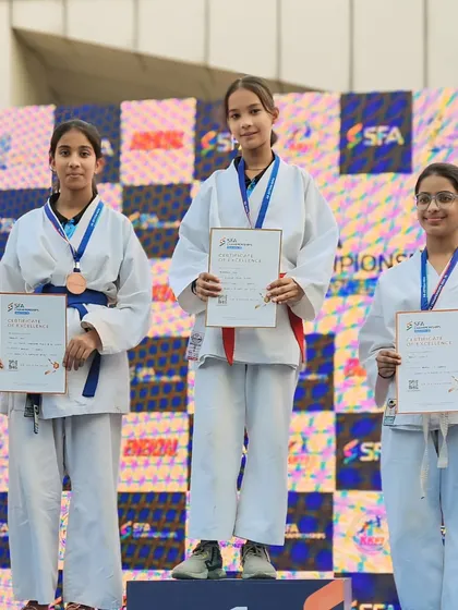My female students showing their medals and certificates on the SFA podium. They are powerful examples of strength and skill.