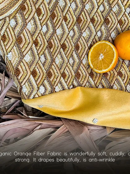 We believe in conscious luxury, which is why we explore innovative, sustainable fabrics. This garment is made from organic orange fiber, a material that is wonderfully soft, drapes beautifully, and is created from citrus waste.