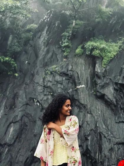 A smiling trekker against a backdrop of dramatic rock formations.
