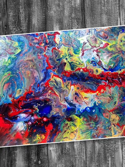A vibrant, multi-colored fluid art painting with dominant reds, blues, and yellows, showcasing a high-energy abstract composition.