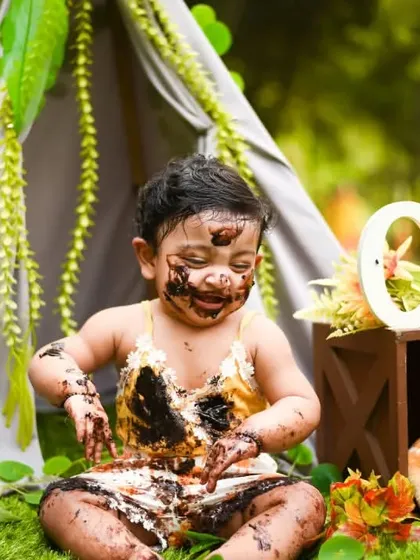 Let them get messy. This is the heart of a great cake smash, where your child can have all the fun they want, just like little Shivya enjoying his chocolate cake in our outdoor jungle theme.