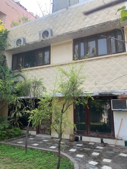 The rear facade of the Art Deco bungalow before renovation, showing the distinctive diamond-patterned tiles and original window frames.