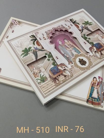 A beautiful die-cut invitation showing a royal couple on elephants, set against a palace backdrop. This design includes multiple inserts and is perfect for a storybook wedding theme.