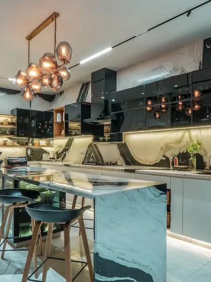 This kitchen is conceived as the heart of the home, blending function with high-end aesthetics. We used bookmatched Panda marble for the island and backsplash, complemented by sleek, high-gloss cabinetry and layered lighting, including a statement pendant fixture.