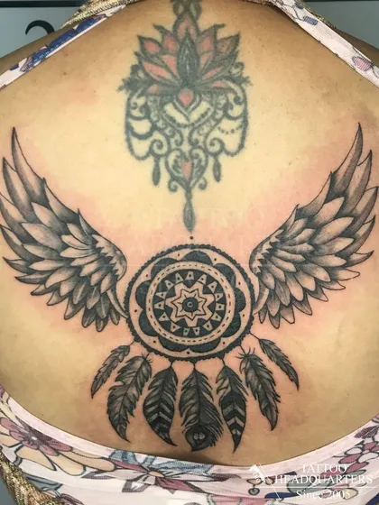 A large backpiece featuring a dreamcatcher with wings, a classic symbol of protection, combined with an ornamental lotus design.