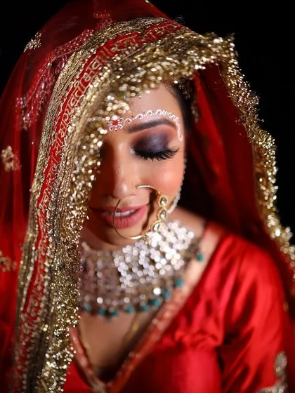 A beautiful close-up of the bride's face, partially covered by her dupatta. The smokey eye and flawless skin create a look of pure elegance.