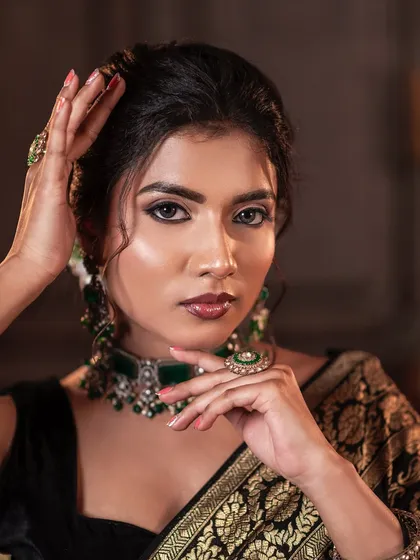 A close-up portrait from the black saree look, showcasing the flawless base and defined features.