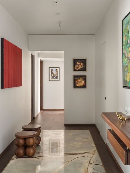 In the West Coast Residence, the hallway is treated as a gallery. A polished marble inlay on the floor defines the path, while the walls are used to display the client's collection of contemporary Indian art.