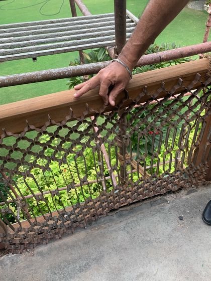 Examining the original rusted but intricate metal jali (screen) of the balcony, which we carefully removed for restoration.