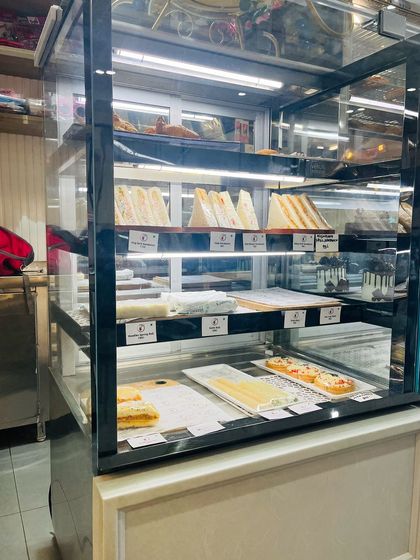A close-up of our savory display case, featuring fresh sandwiches, patties, and other quick bites, all ready for you to enjoy.