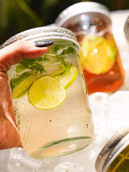 A hand holding our lime and mint soda, a classic and popular choice.