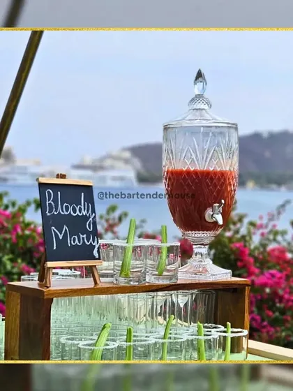 Our Bloody Mary station, set against a beautiful waterside view. We serve this classic savory cocktail in a large dispenser for guests to help themselves.