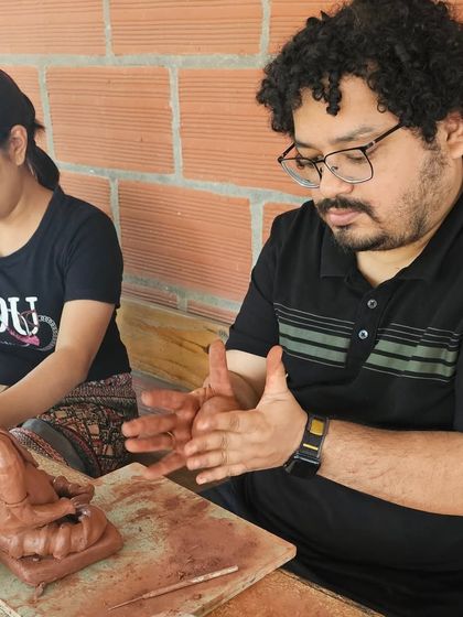 A couple works together, each sculpting their own Ganesha idol. It's a wonderful activity to share with a loved one during the festive season.