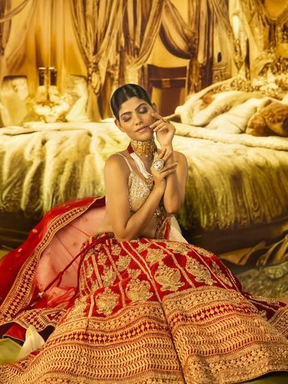 The essence of regal grace. This opulent bedroom scene is a projected backdrop, with lighting carefully placed to highlight the intricate details of the ethnic wear and create a luxurious feel.