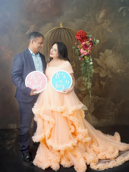 A fun gender reveal for twins. This couple is all smiles as they hold signs for "It's a girl" and "It's a boy," celebrating their two little miracles on the way.