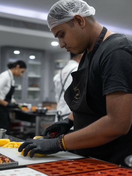 Intense focus from a participant during the fruit preparation stage of our Viennoiserie class for The Oberoi's culinary team.