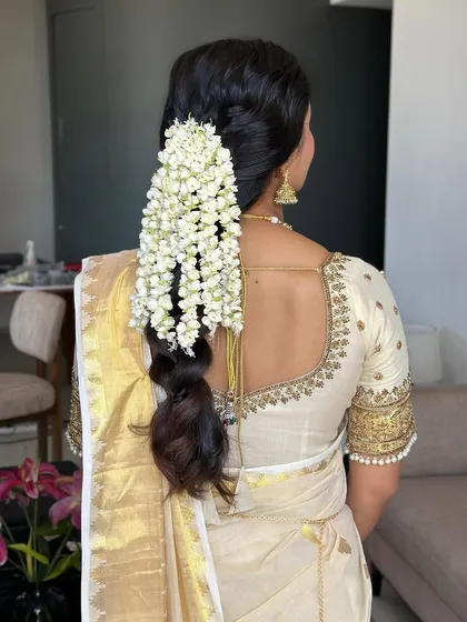 A detailed shot of the traditional gajra hairstyle. The fragrant jasmine flowers are a classic element of South Indian bridal beauty, and we made sure they were perfectly tucked.