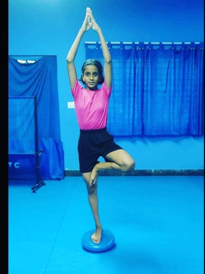 A young player demonstrates excellent focus and balance in the tree pose. Our yoga sessions are adapted for all age groups to develop physical control and mental calm.