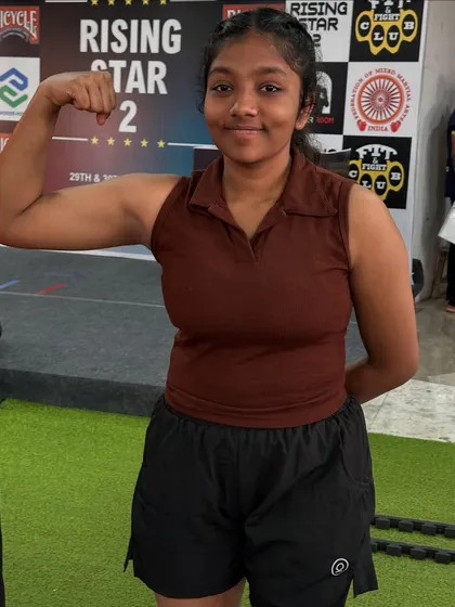 Disha, flexing and focused after her weigh-in. She's ready to step into the ring and showcase her power.