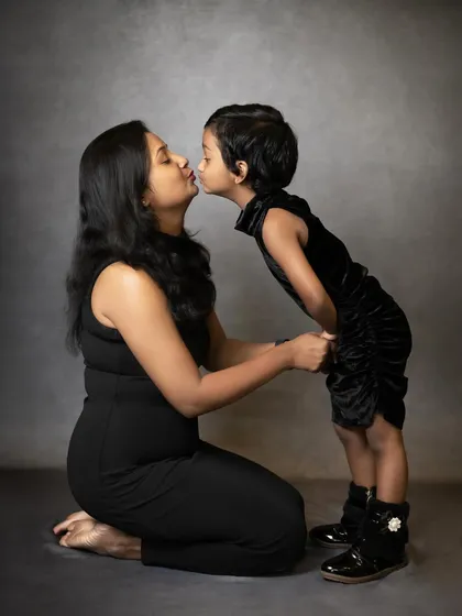 A mother's love is a powerful story. This simple, emotional portrait of a mother and daughter sharing a kiss against a classic studio backdrop is a perfect example of the timeless parent-child moments we aim to capture.