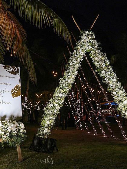 The stunning floral and light teepee arch stands next to a welcome sign for the reception of Aysha and Farhan, ready to greet guests for a night of celebration.