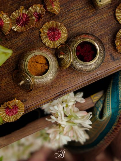 A beautiful detail shot of traditional haldi and kumkum containers. These small, authentic touches are essential for creating a truly Indian wedding experience, adding layers of cultural significance to the decor.