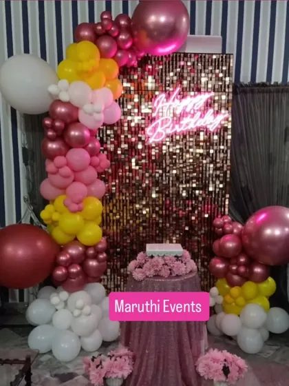 Here’s a perfect example of a modern and stylish birthday setup. A shimmering gold sequin wall provides a dazzling photo backdrop, complemented by a custom neon sign and a colorful organic balloon garland.