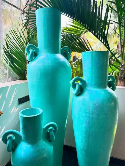 Another close-up of the Del Mar planters, showcasing their vibrant color against a backdrop of palm trees.