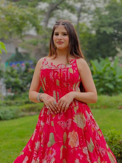 A close-up of our pink floral gown. The corset top and butterfly motifs make it a whimsical and pretty choice for a day event.