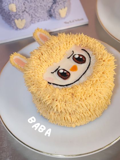 This is Baba, a sweet yellow character from our limited edition Labubu cake collection, served on a plate and ready to be devoured.